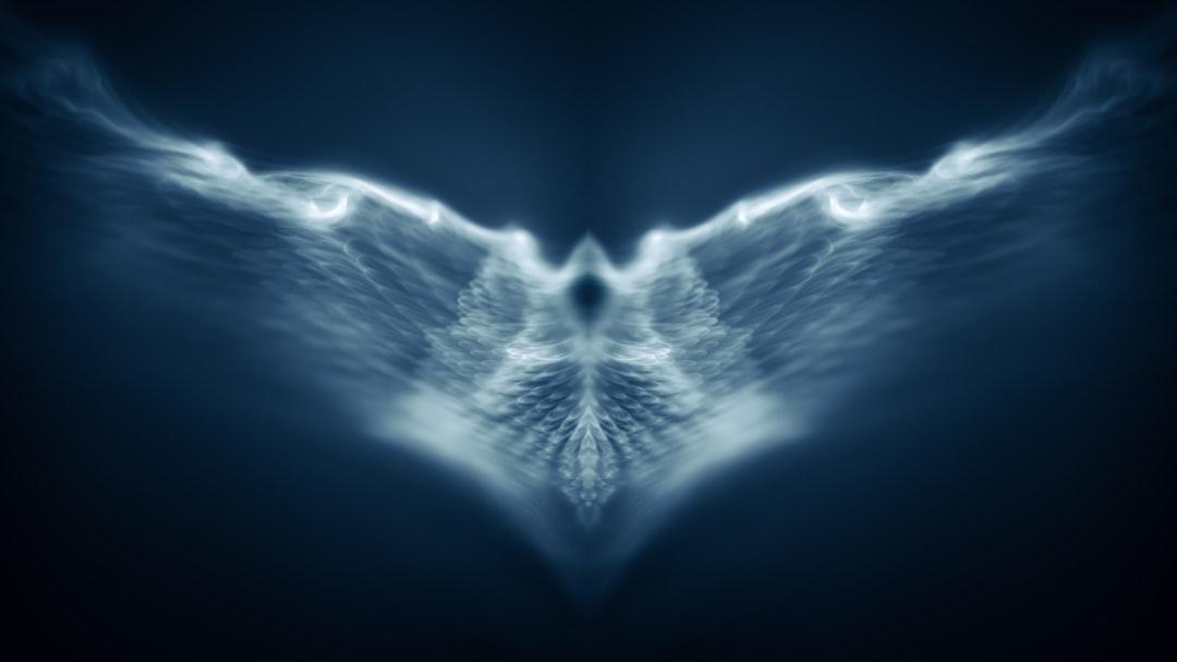 Photo by Marek Piwnicki an abstract image of a blue bird with wings